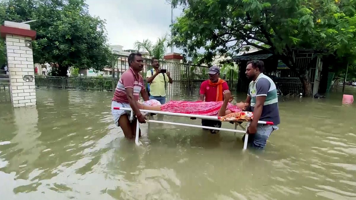 Varanasi hospital staff carry patient through flooded road after heavy rain