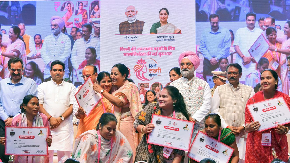 Delhi CM Rekha Gupta embraces beneficiary at Lakshmi Yojana event