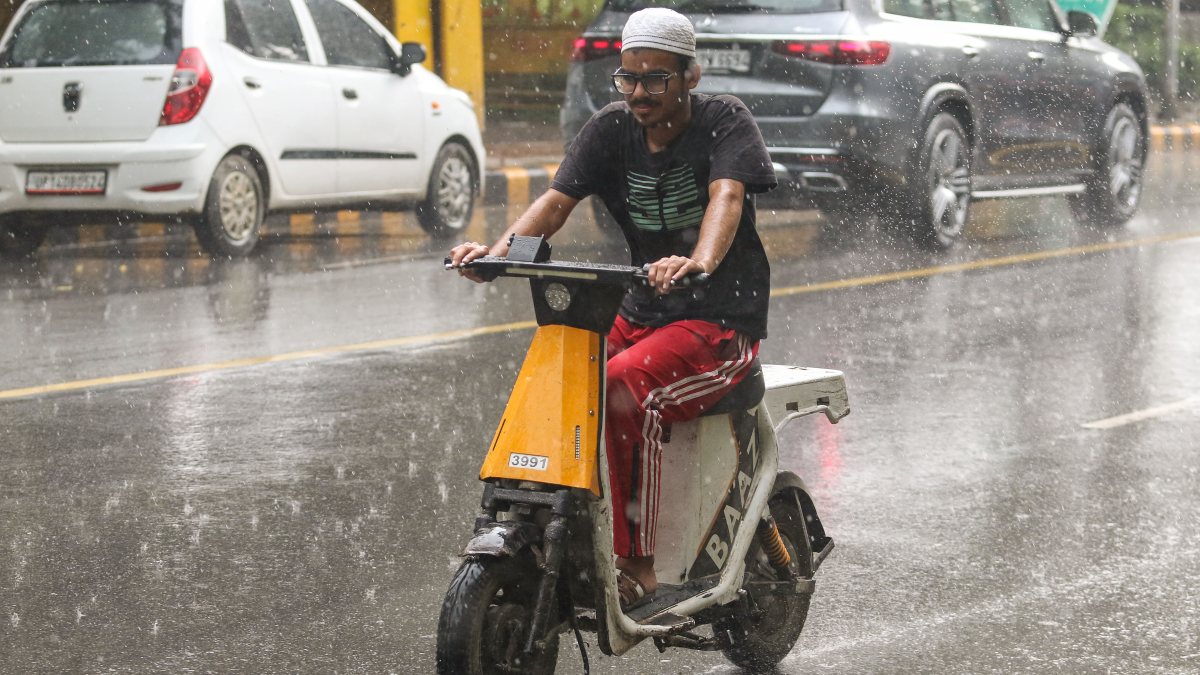 Commuters navigate waterlogged roads amid heavy rain in New Delhi