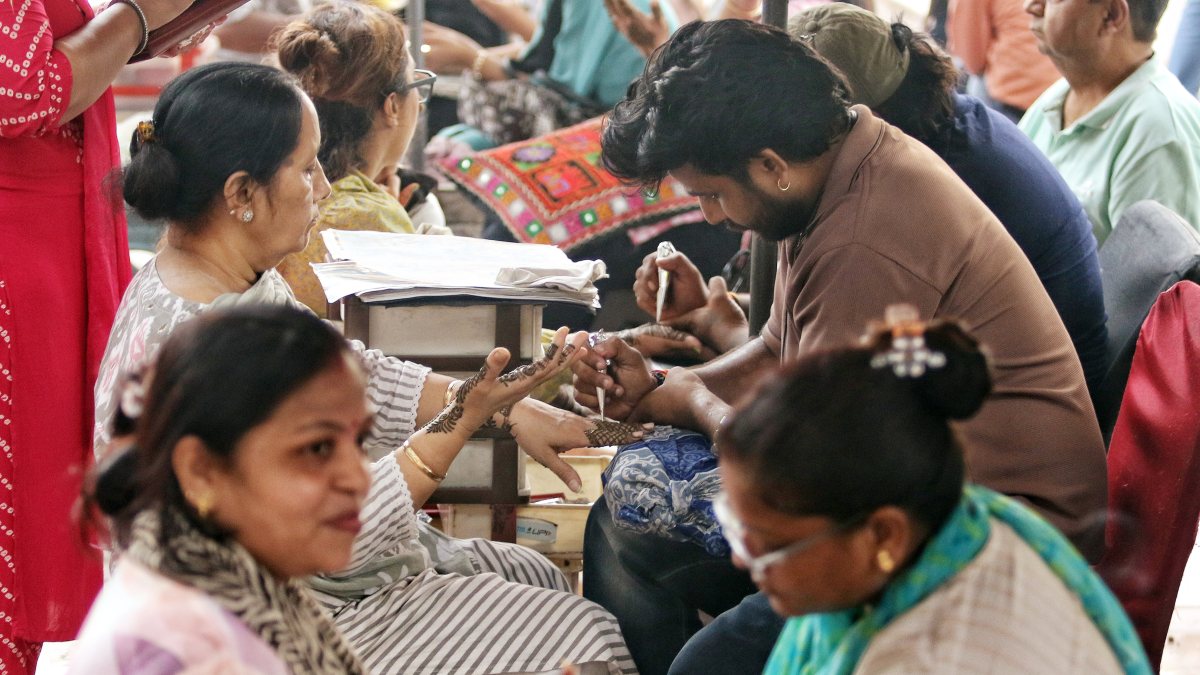 Women apply mehendi ahead of Raksha Bandhan in New Delhi