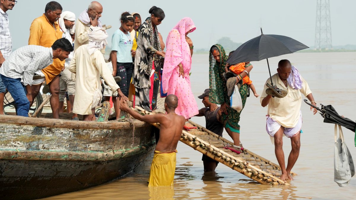 Flood-hit Patna residents wade through Ganga waters to safety