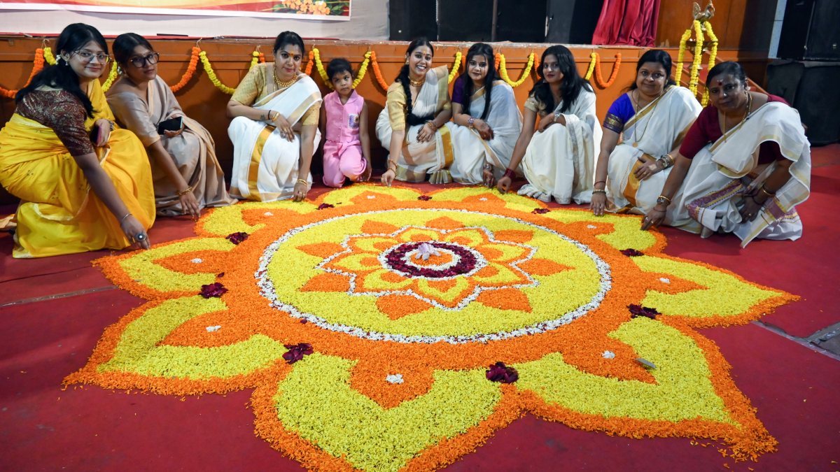 Women pose with floral rangoli at Onam fest in Patna