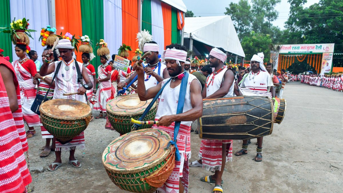 Tribal men drum in traditional attire at Ranchi Adivasi gathering