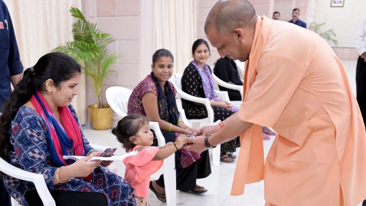 Yogi Adityanath offers chocolate to child at Lucknow Janta Darshan