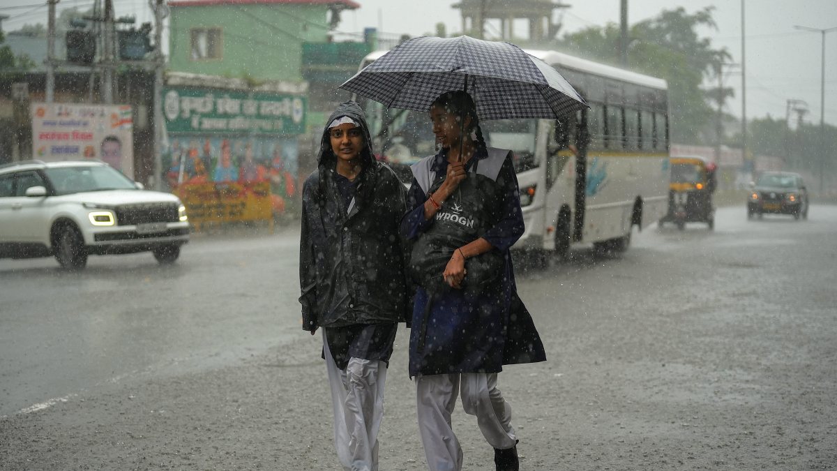 Heavy rain drenches Nainital as schoolgirls share umbrella