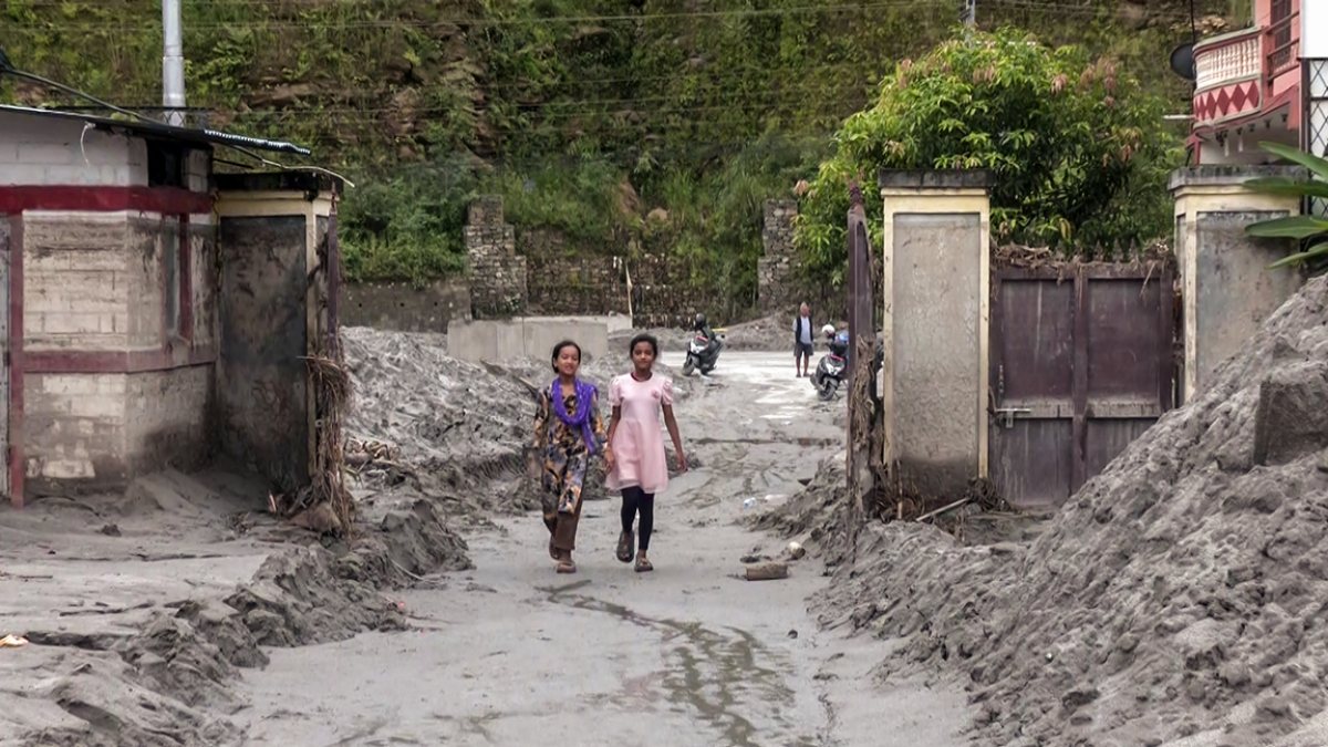 Children walk through sludge after Nepal floods hit school