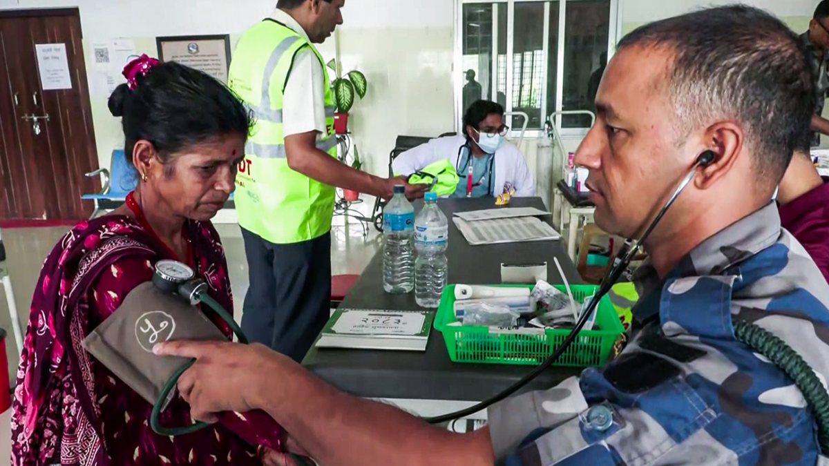 Army doctor examines flood-affected woman in Nuwakot