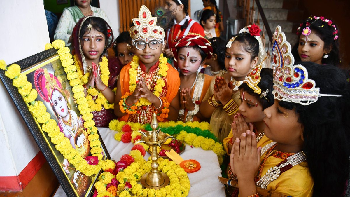 Children in Krishna-Radha attire pray on Janmashtami eve