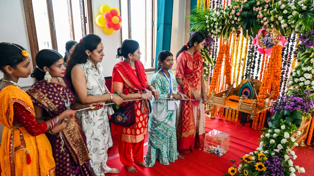 Devotees swing Lord Krishna's cradle at ISKCON Temple on Janmashtami