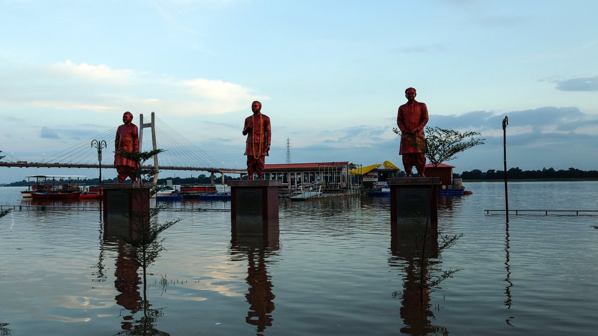 Partially submerged statues in flooded Yamuna at Prayagraj