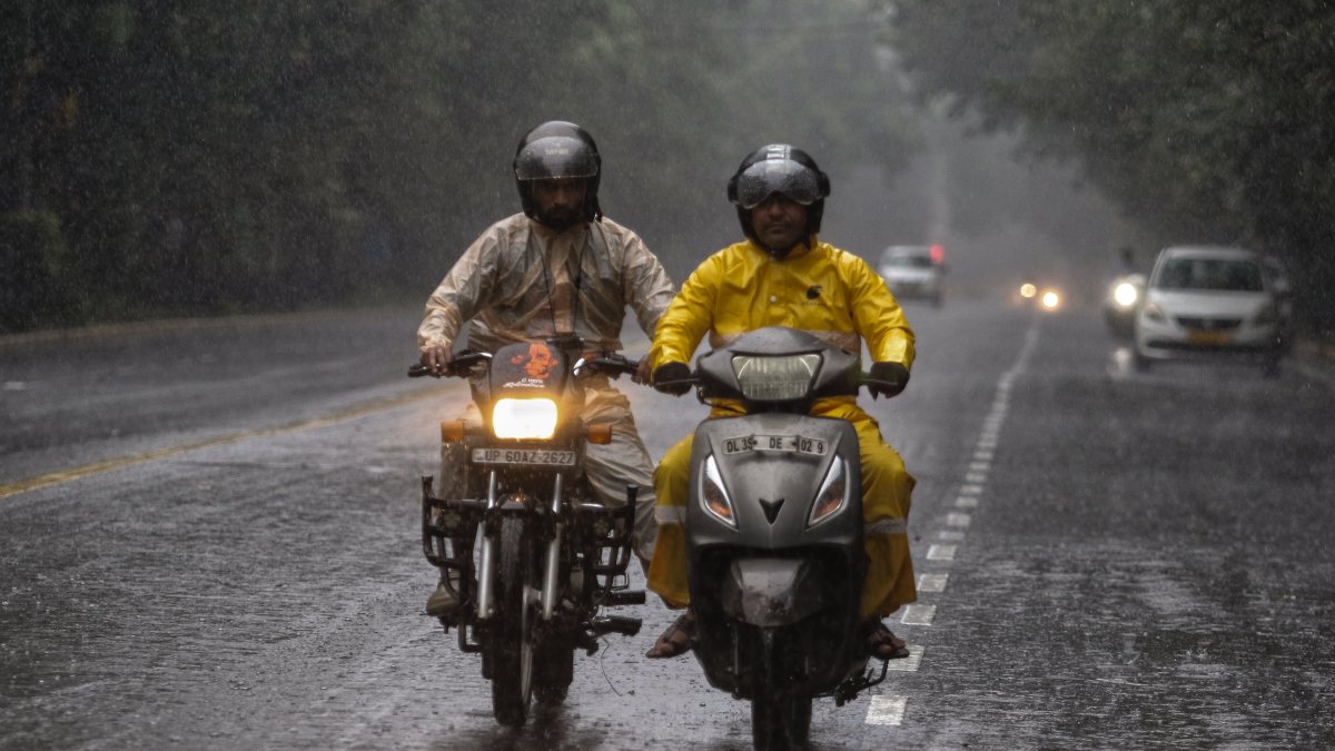 Delhi commuters navigate rain-soaked roads amid downpour