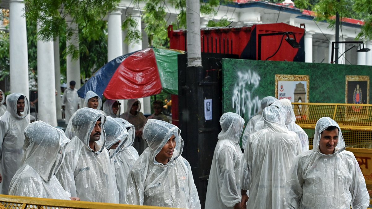 Delhi Police stand guard in rain near Parliament Street