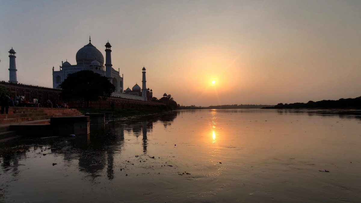 Sunset paints golden hues over Yamuna behind Taj Mahal
