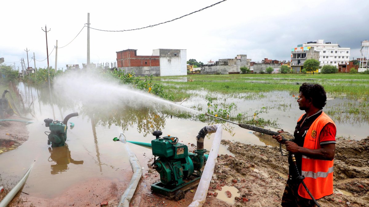 Lucknow municipal staff disinfect flooded streets after heavy rain