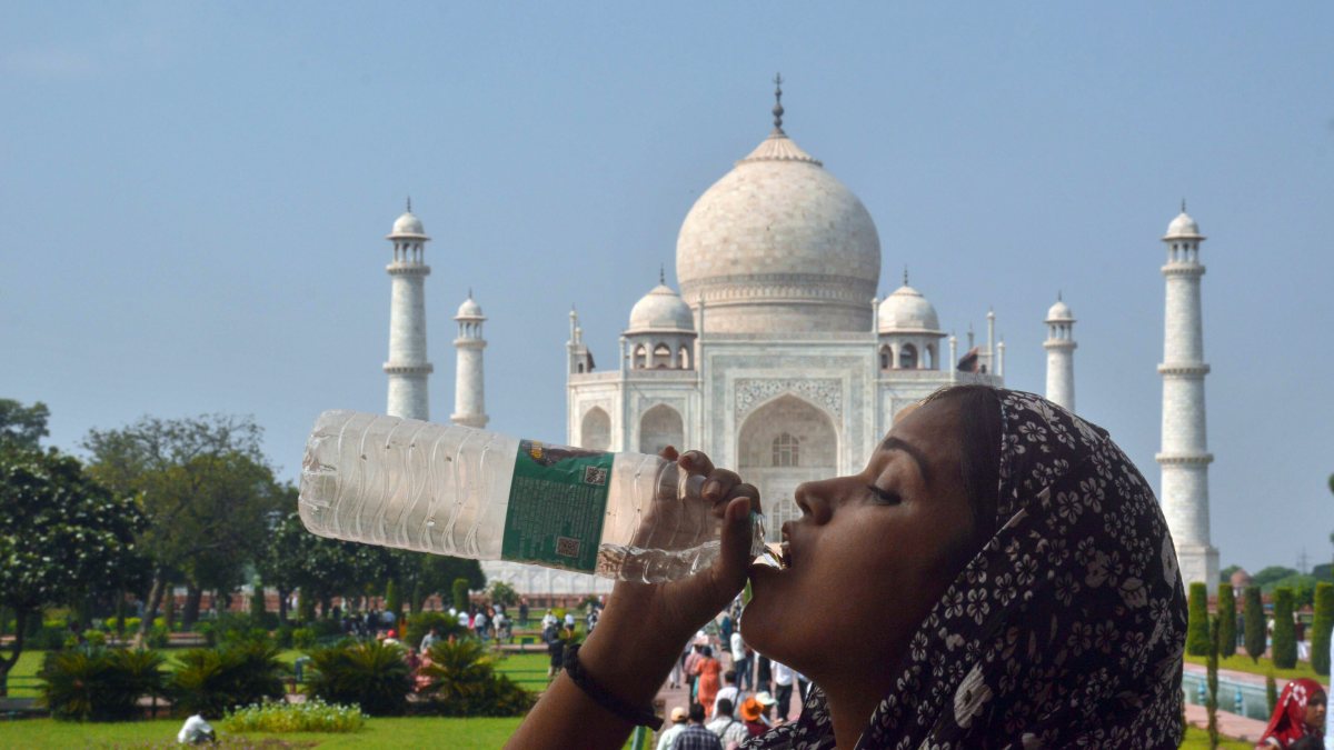 Tourist drinks water amid scorching heat at Taj Mahal