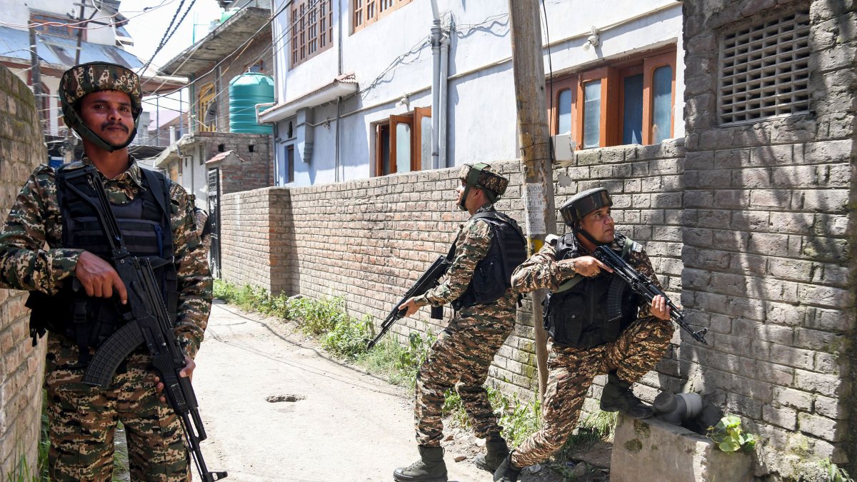 Security personnel take positions during Srinagar search operation