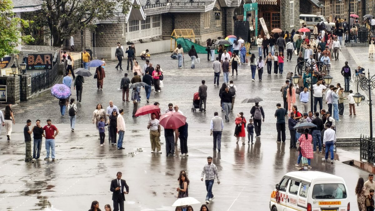 Shimla residents walk with umbrellas amid intermittent rain