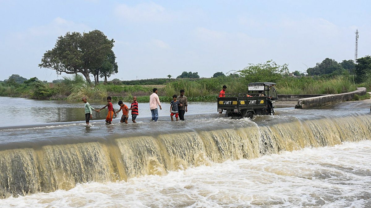 Children navigate flooded bridge in Kanpur