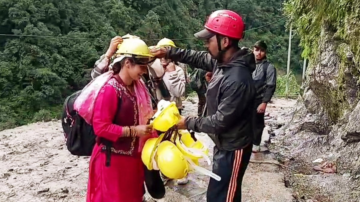 DDRF official hands helmet to pilgrims on Kedarnath route