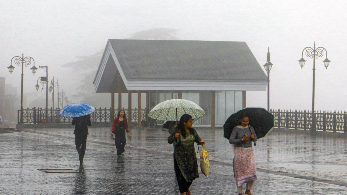 Morning rain and mist in Shimla as people walk with umbrellas