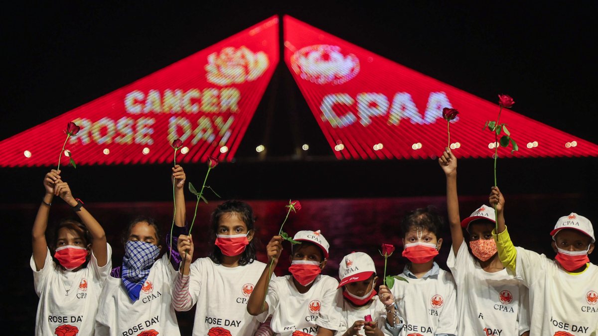 Cancer patients hold roses at illuminated Mumbai sea link