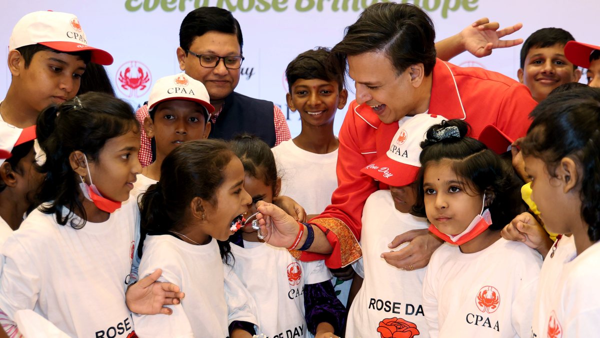 Vivek Oberoi offers cake to child at cancer rose day event
