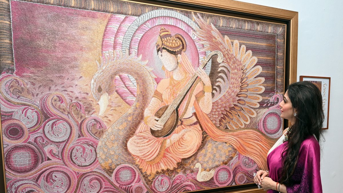 Astrologer Jai Madaan views Saraswati painting at Delhi art exhibition