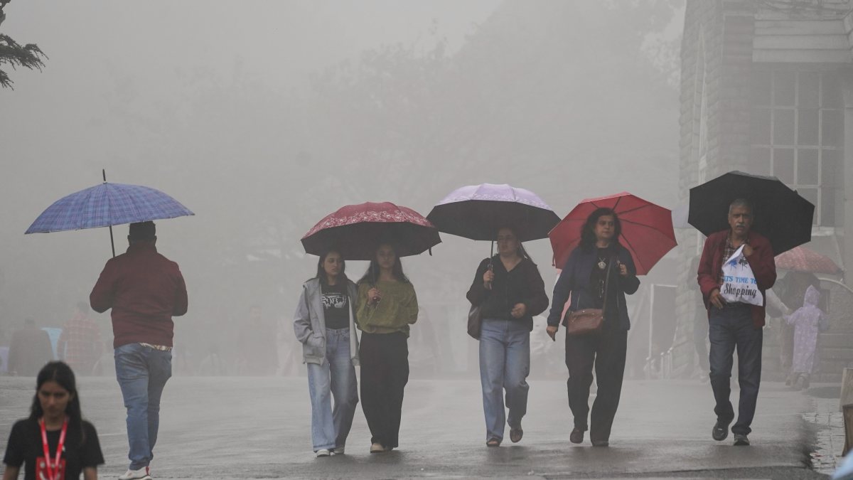 Heavy rain lashes Shimla as pedestrians walk with umbrellas