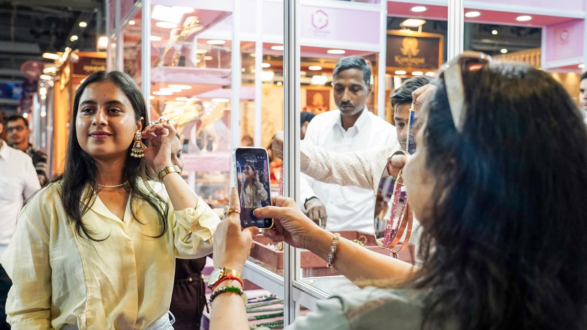 Woman photographs another at Delhi jewellery fair