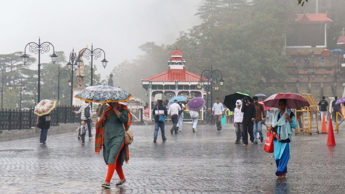 Light rain in Shimla as people walk with umbrellas