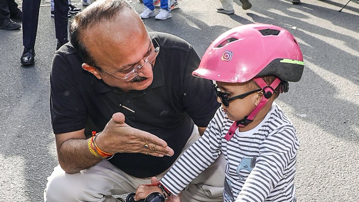 Delhi minister Ashish Sood interacts with child at Raahgiri Day