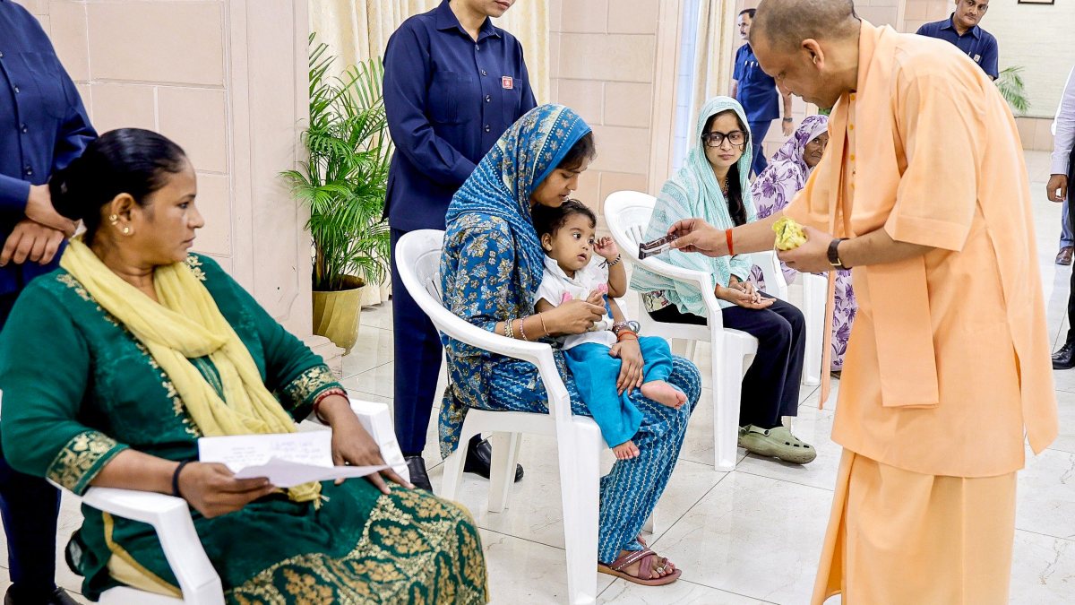 Yogi Adityanath gives chocolate to child at Janata Darshan