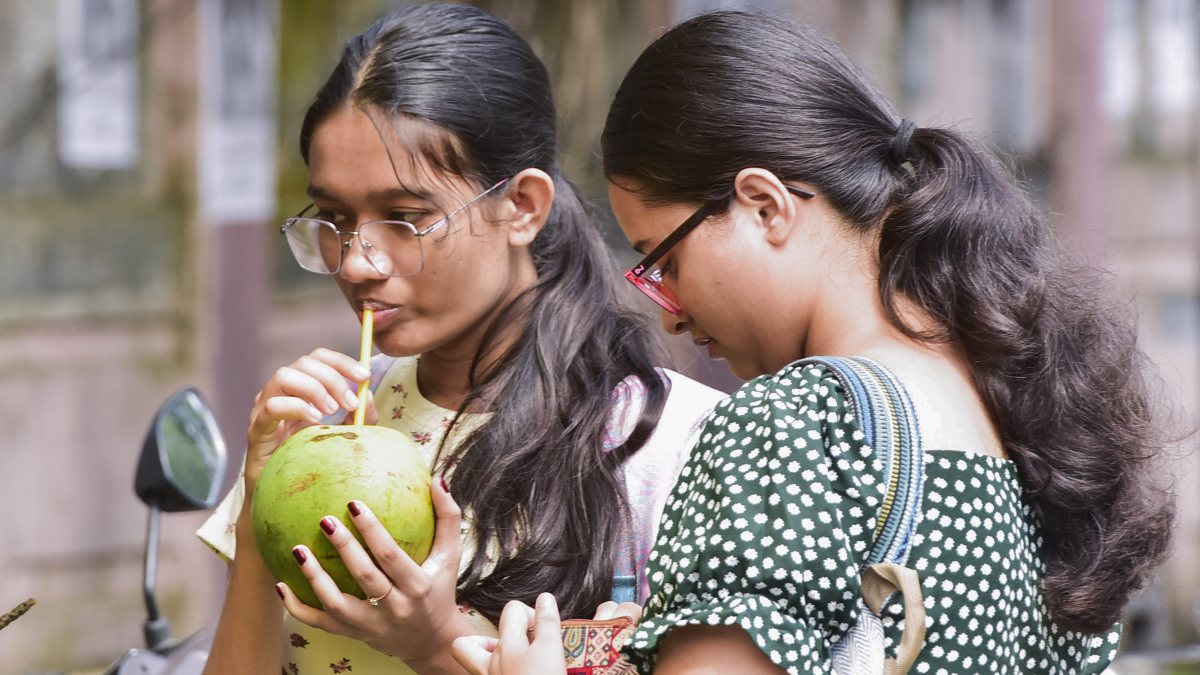 Woman drinks tender coconut water at Guwahati roadside stall