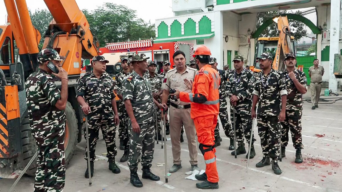 Rescue official meets security personnel at Delhi building collapse site