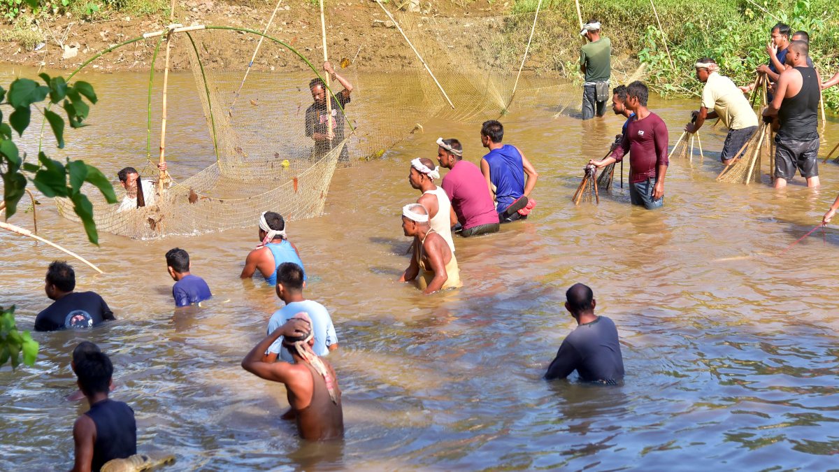 Villagers catch fish with nets in Boko River in Kamrup