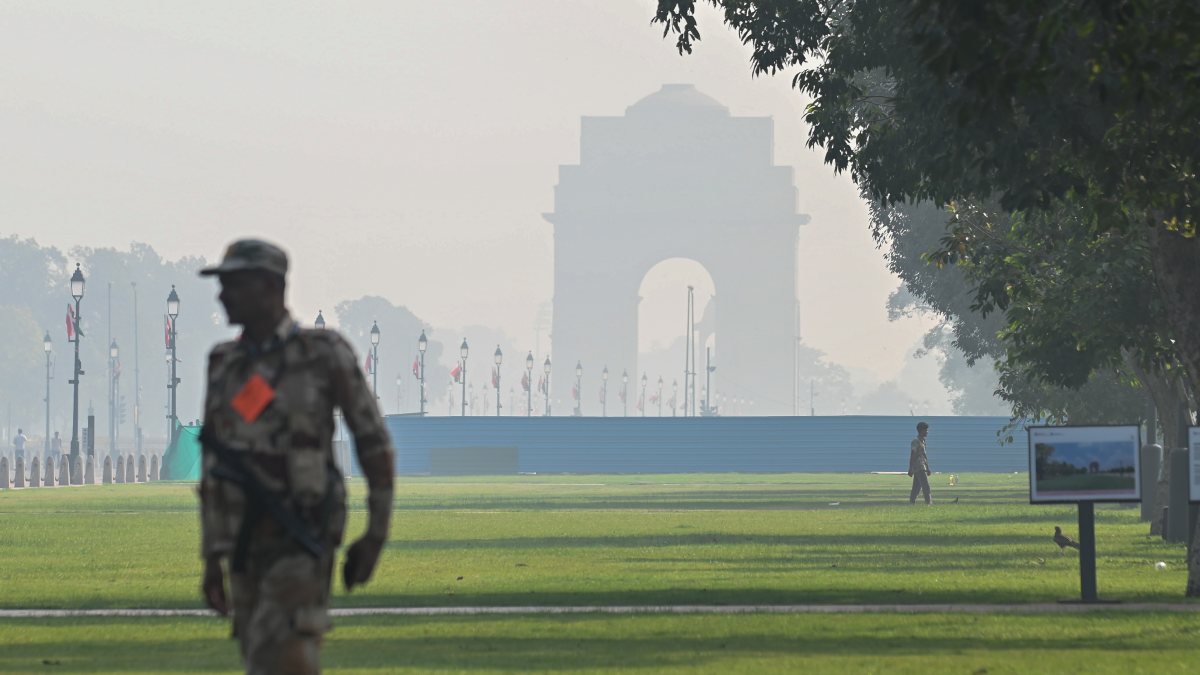 Delhi haze thickens near India Gate as security official stands guard