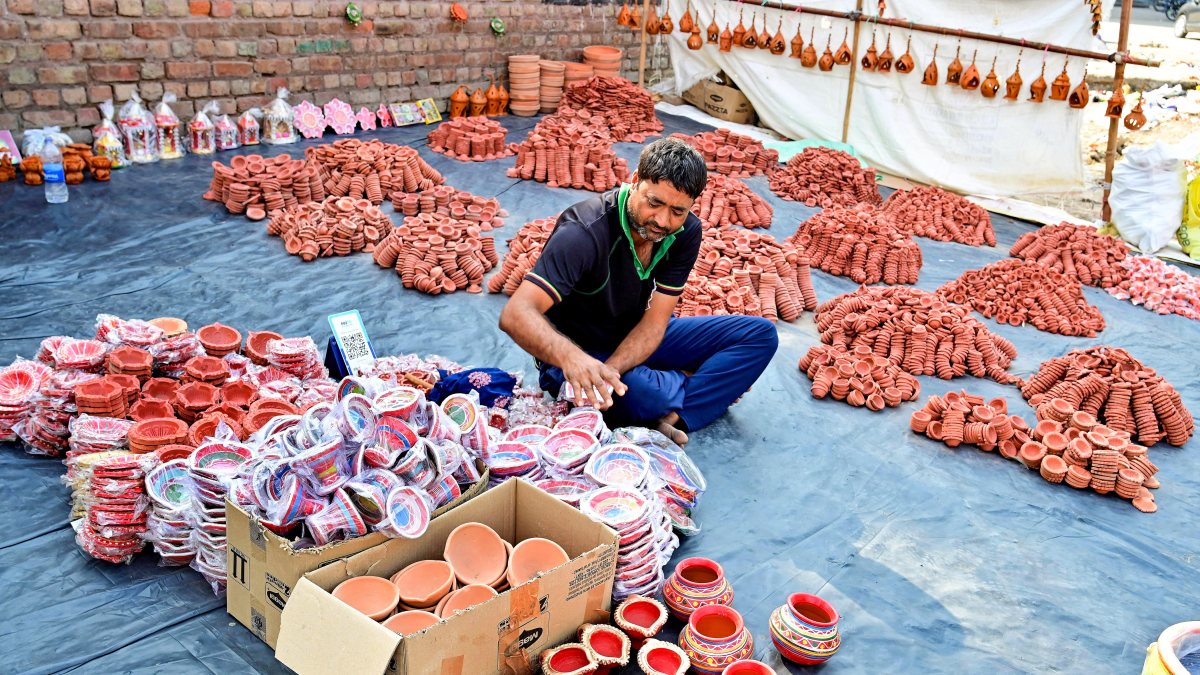 Street vendor arranges diyas and Karwa pots ahead of Karwa Chauth in Bikaner