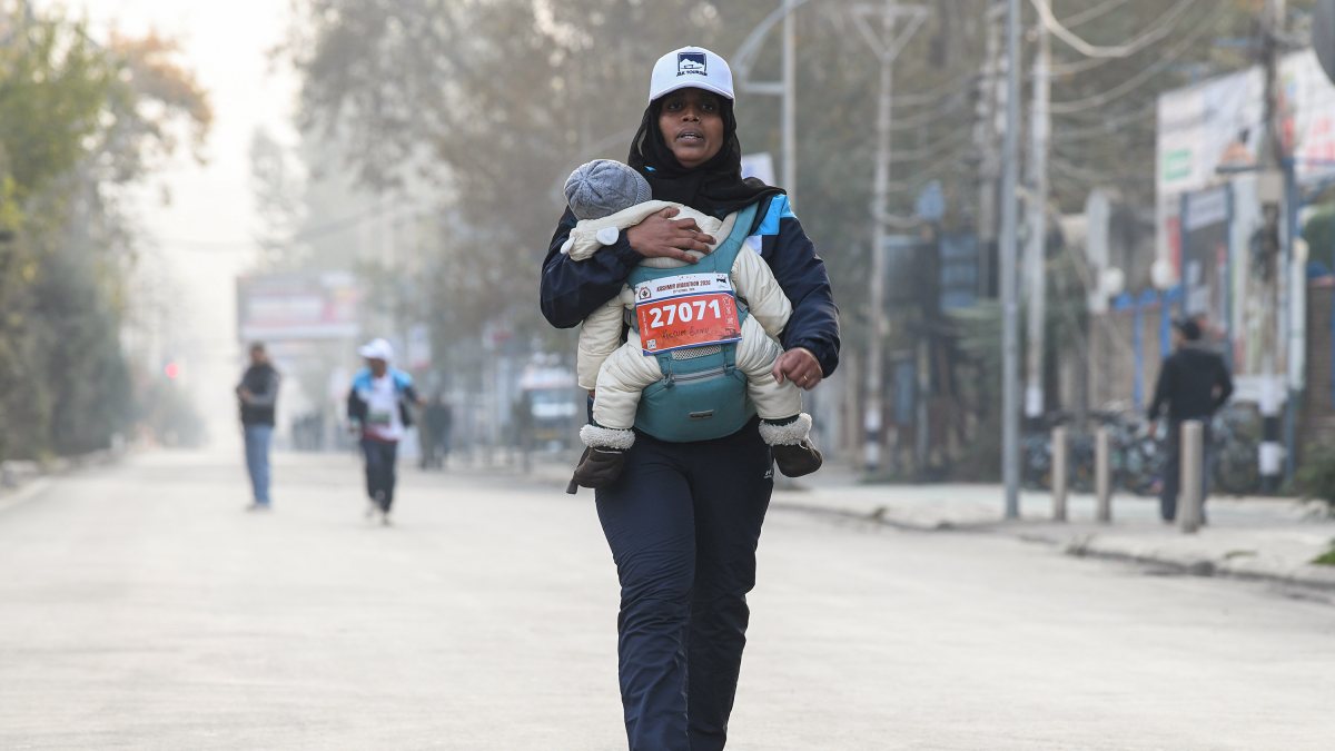 Woman carries child during Kashmir Marathon 3.0 in Srinagar