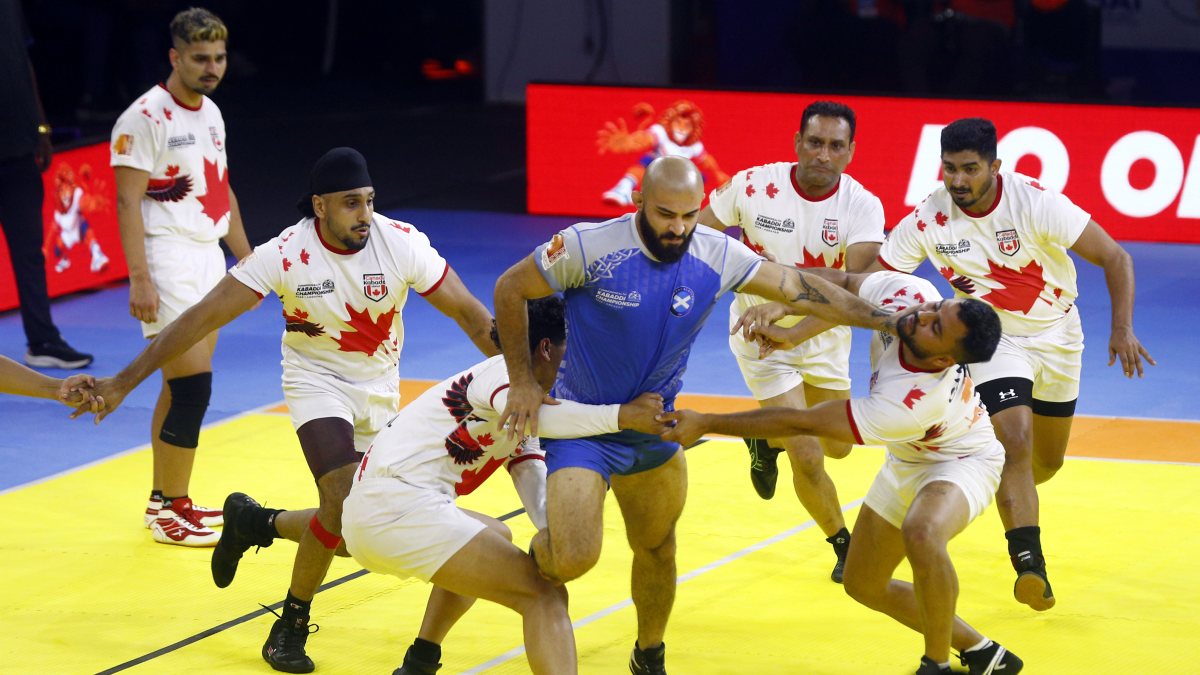 Canadian players tackle Scottish player at Commonwealth Kabaddi