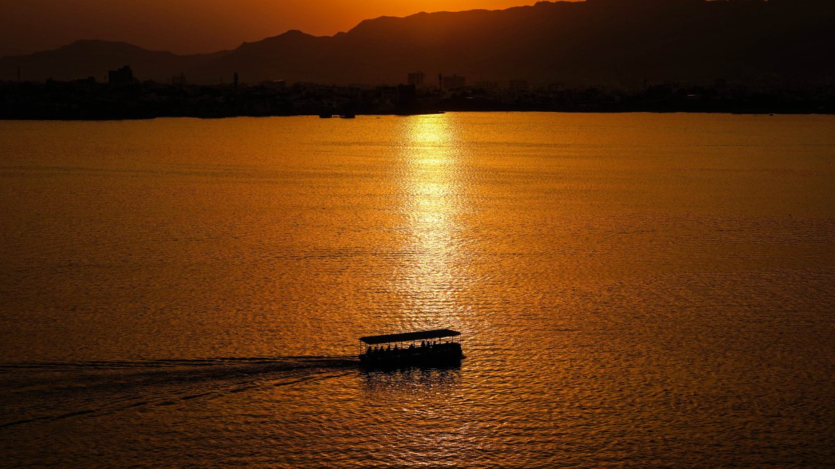 Tourists enjoy sunset boat ride at Ana Sagar Lake in Ajmer
