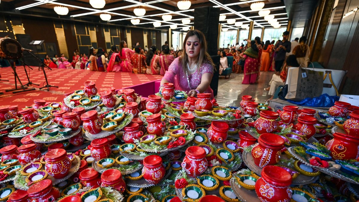 Woman arranges decorated Karvas and diyas ahead of Karva Chauth in Ahmedabad