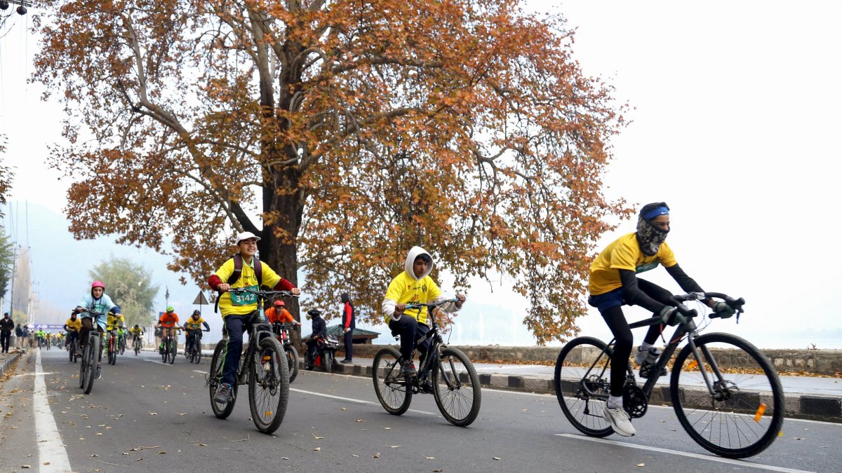 Cyclists race along Dal Lake in Srinagar police event