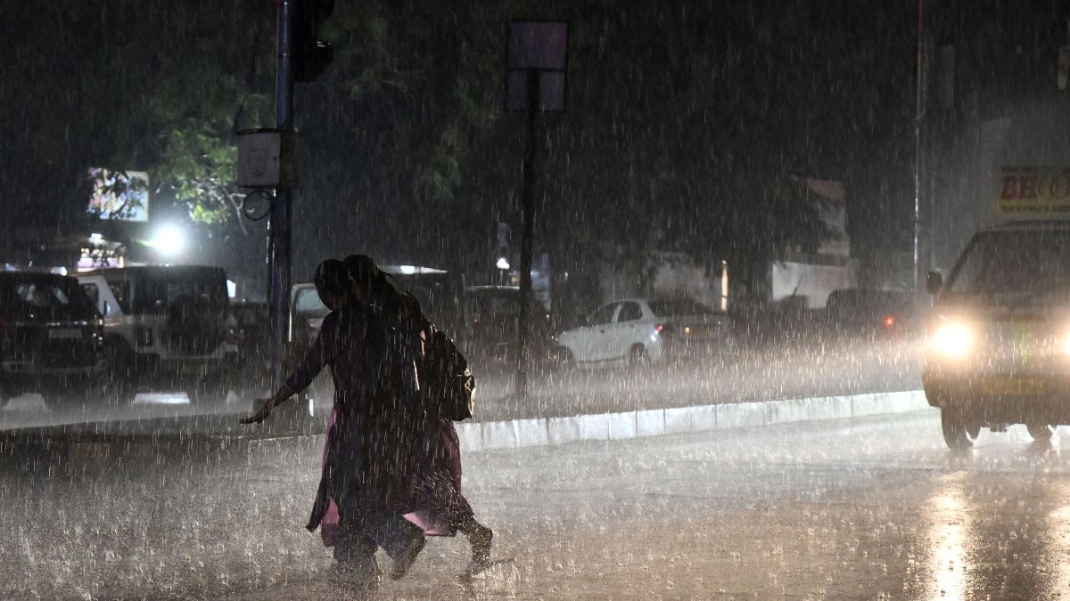 Hyderabad pedestrians cross road amid rain